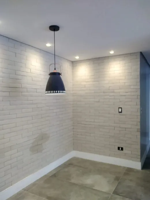 Parede de tijolos off-white com pendente de luz quente